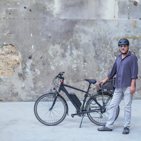 man standing in front of electric bicycle